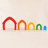 Wooden rainbow arches arranged separately on a cream surface showing each color in the set