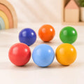 Close-up of a single wooden rainbow ball showing smooth painted finish and round shape