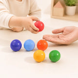 Wooden rainbow balls styled in a warm nursery play scene