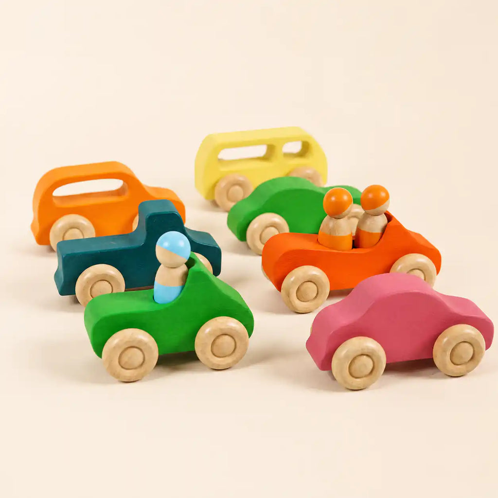 Wooden rainbow car with peg doll passengers on a soft cream surface, hero shot