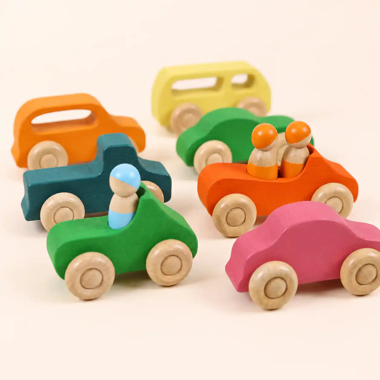 Side view of wooden rainbow car showing peg dolls seated and rolling wheels