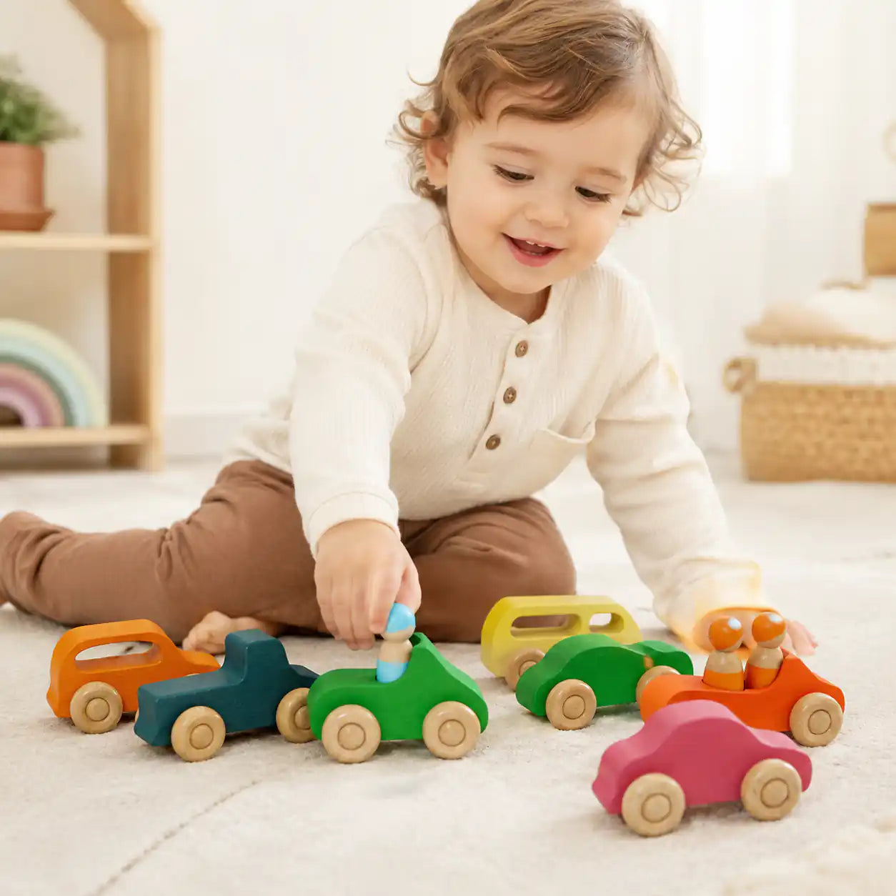 Wooden rainbow car and peg doll set beside a ruler showing size and scale