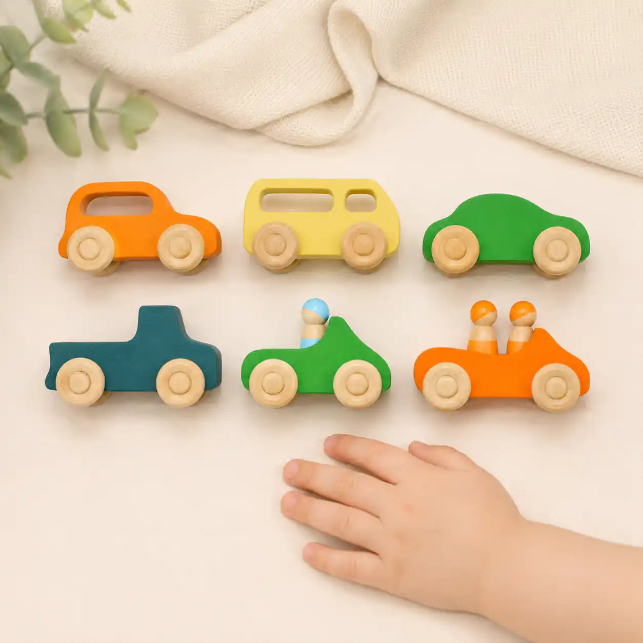 Top-down view of wooden rainbow car with peg dolls seated inside