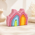 Wooden rainbow coral stacker with colorful coral-shaped pieces stacked on a soft cream surface, hero shot