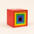 Wooden rainbow nesting cubes arranged in a graduated row showing each size and color