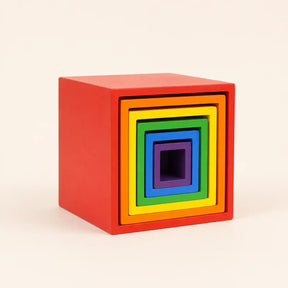 Wooden rainbow nesting cubes arranged in a graduated row showing each size and color