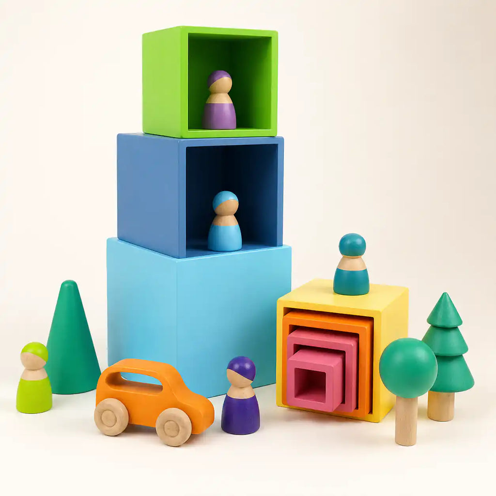 Wooden rainbow nesting cubes stacked into a tower on a soft cream surface, hero shot
