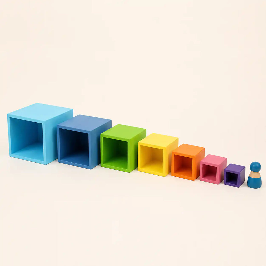 Wooden rainbow nesting cubes partially nested showing color layers tucking inside one another