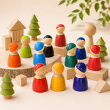 Small hands holding wooden rainbow peg doll friends on a warm neutral surface