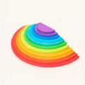 Wooden rainbow semicircles set with 11 nesting half-moon discs in classic rainbow colors on cream background, Waldorf-inspired