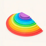 Wooden rainbow semicircles set with 11 nesting half-moon discs in classic rainbow colors on cream background, Waldorf-inspired