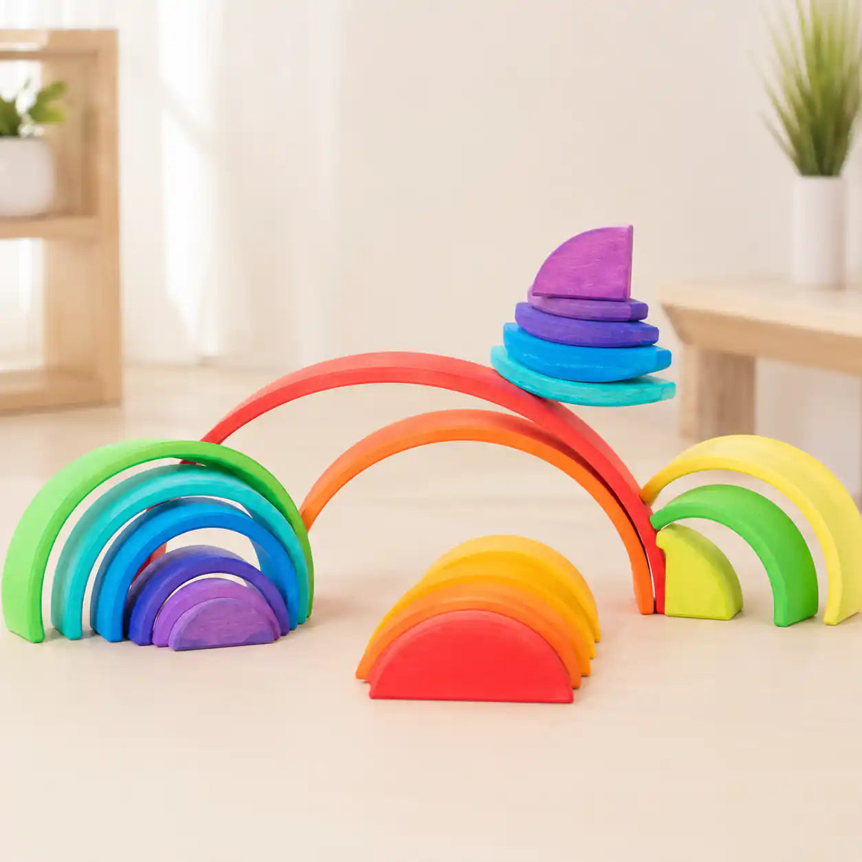 Wooden rainbow arches and semicircles arranged together in a creative open-ended building scene with soft natural light