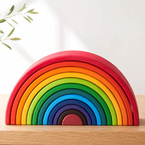 12-piece wooden rainbow stacker in Classic Rainbow colors arranged in nested arches on a cream background