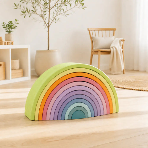 Macaron pastel wooden rainbow stacker styled on a play shelf in a warm, Montessori-inspired toddler playroom