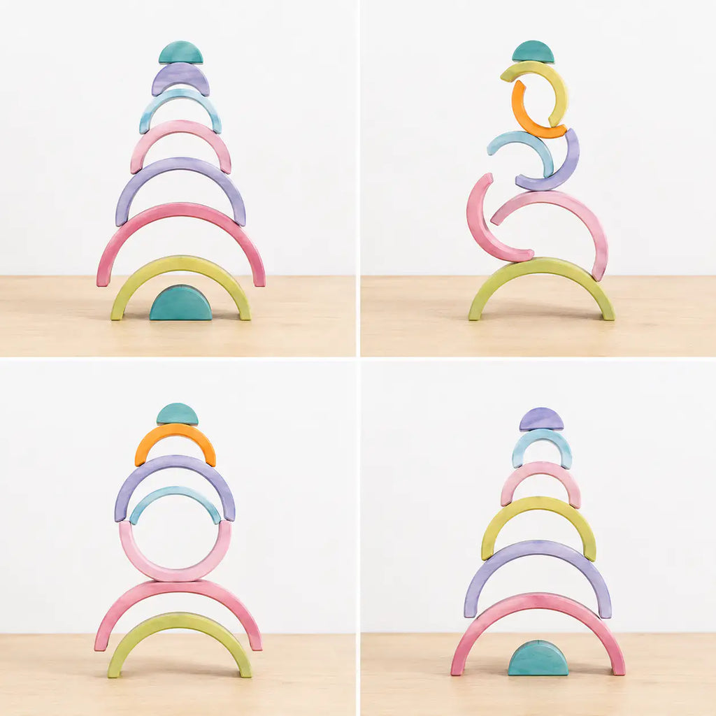 Macaron pastel rainbow stacker pieces balanced into a stacked tower showing fine motor and stacking play