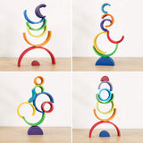 Rainbow stacker pieces balanced into a stacked tower showing fine motor and stacking play