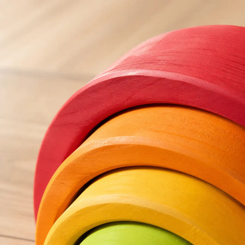 Close-up of the smooth matte finish and sanded wood grain on a rainbow stacker arch piece