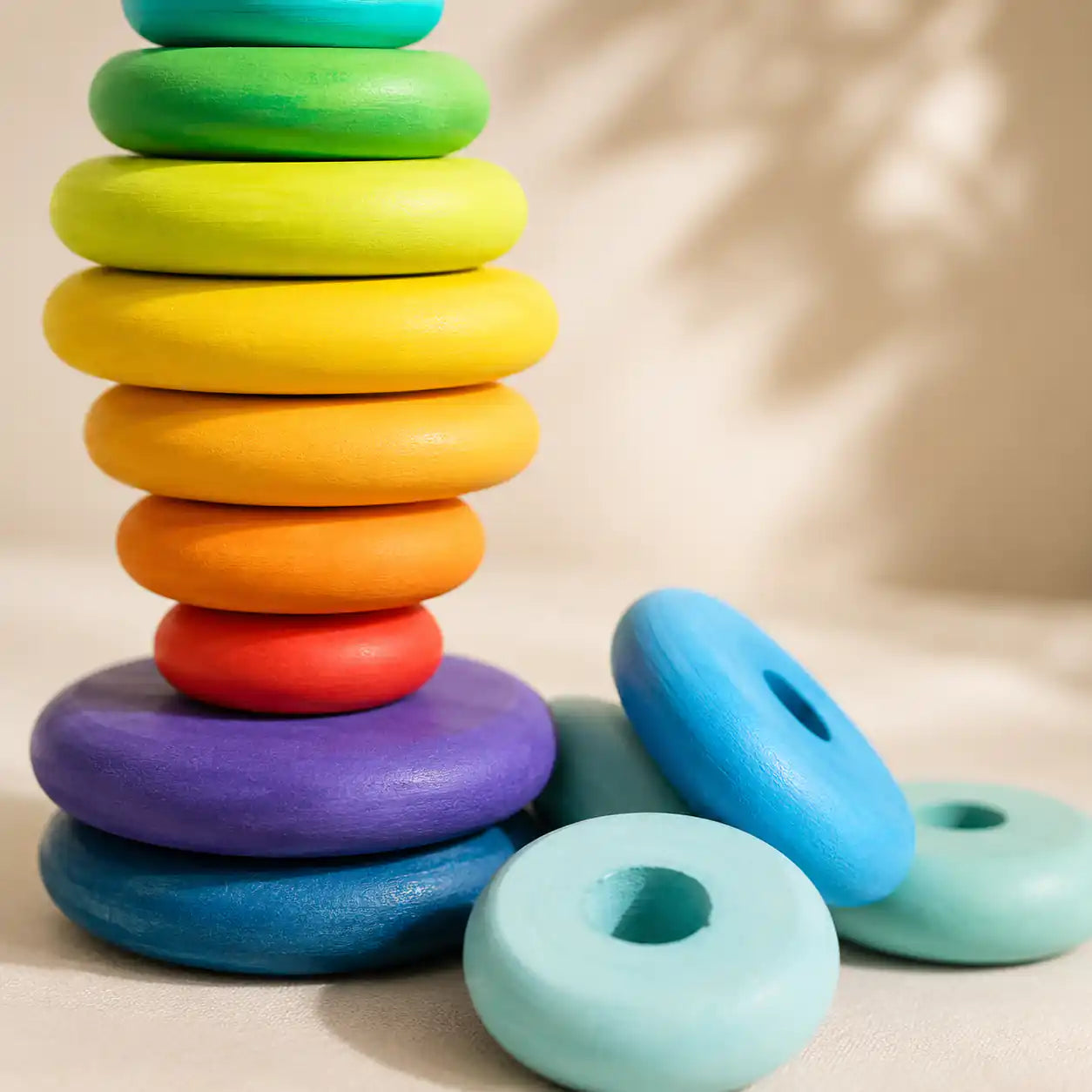 Close-up of stacked rainbow wooden discs showing smooth matte finish and graduated sizes