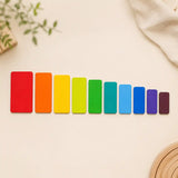 Wooden rainbow stacking tablets laid out in a line showing graduated sizes and rainbow color order