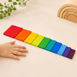 Wooden rainbow stacking tablets beside a ruler and tape measure showing size and scale