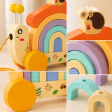 Wooden snail pull-along toy rolling on its yellow wheels with the pull string trailing behind, first walker for toddlers