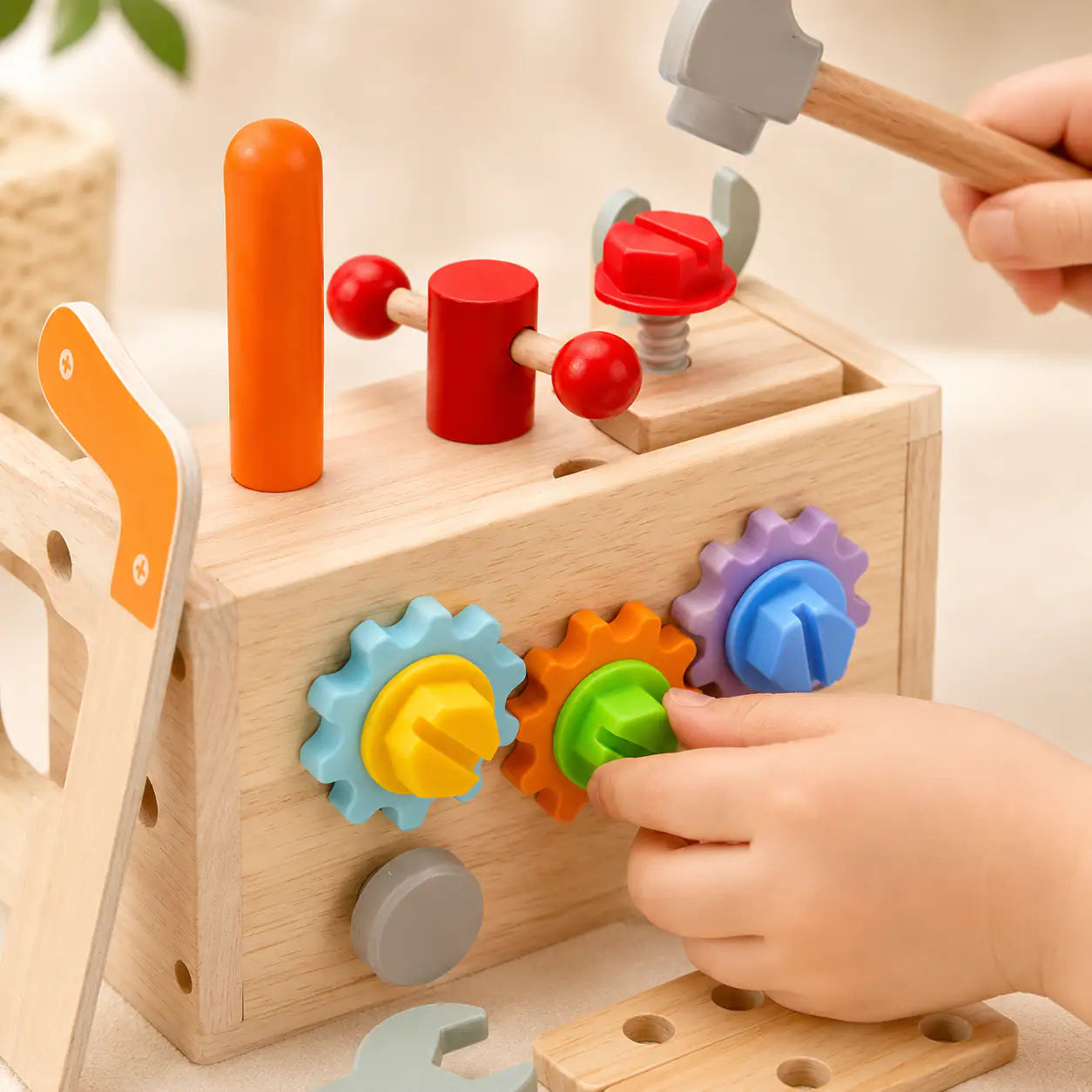 Close-up of the wooden pretend hammer, wrench, screwdriver and saw from the toddler tool box